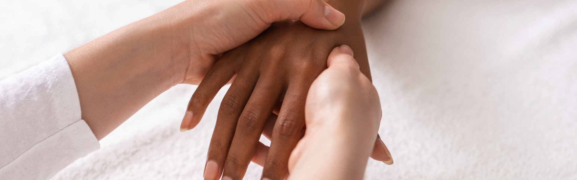 Masseuse making acupuncture hand massage for black woman at spa, view above, cropped